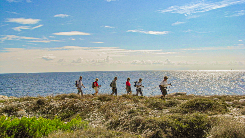 Wandergruppe unterwegs an der Küste Istriens im Hintergrund das glitzernde Meer. Wandergruppe unterwegs an der Küste Istriens im Hintergrund das glitzernde Meer.