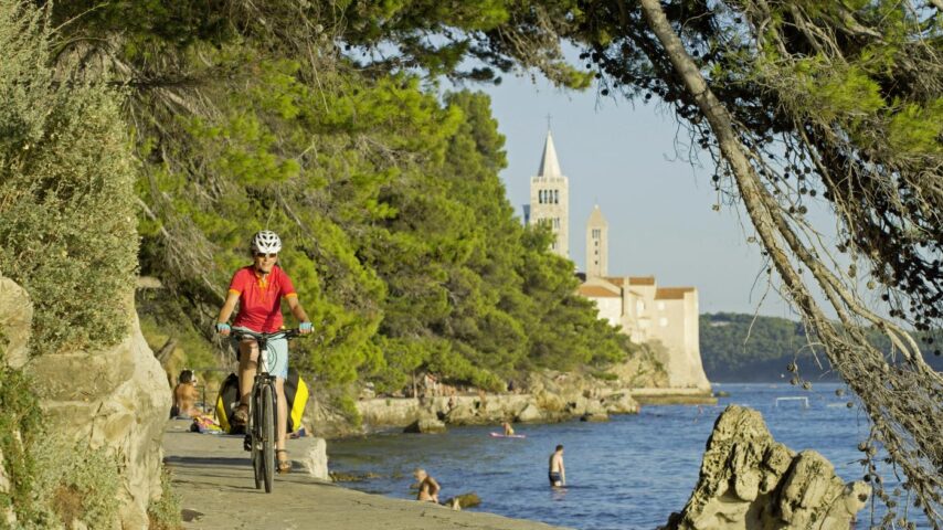 Radfahrerin an der Küste in Rab Radfahrerin an der Küste in Rab