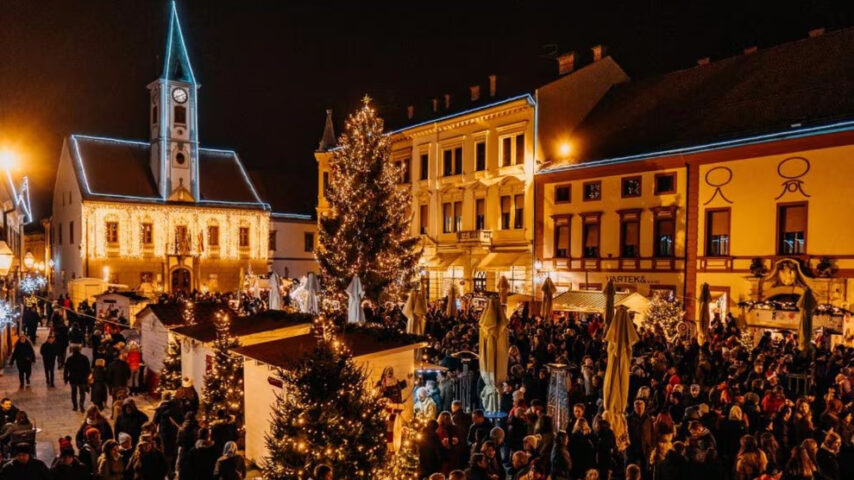 Weihnachtsmarkt mit vielen Leuten, Lichterketten, Weihnachtständen und Hütten, Weihnachtsbäume Weihnachtsmarkt mit vielen Leuten, Lichterketten, Weihnachtständen und Hütten, Weihnachtsbäume